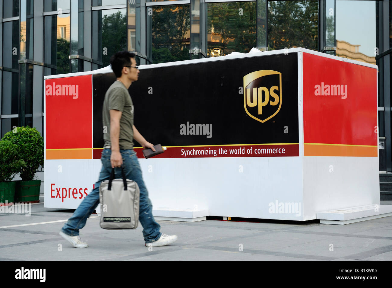 A Chinese man walks past a UPS express box in Beijing, China. 06-Jul-2008 Stock Photo