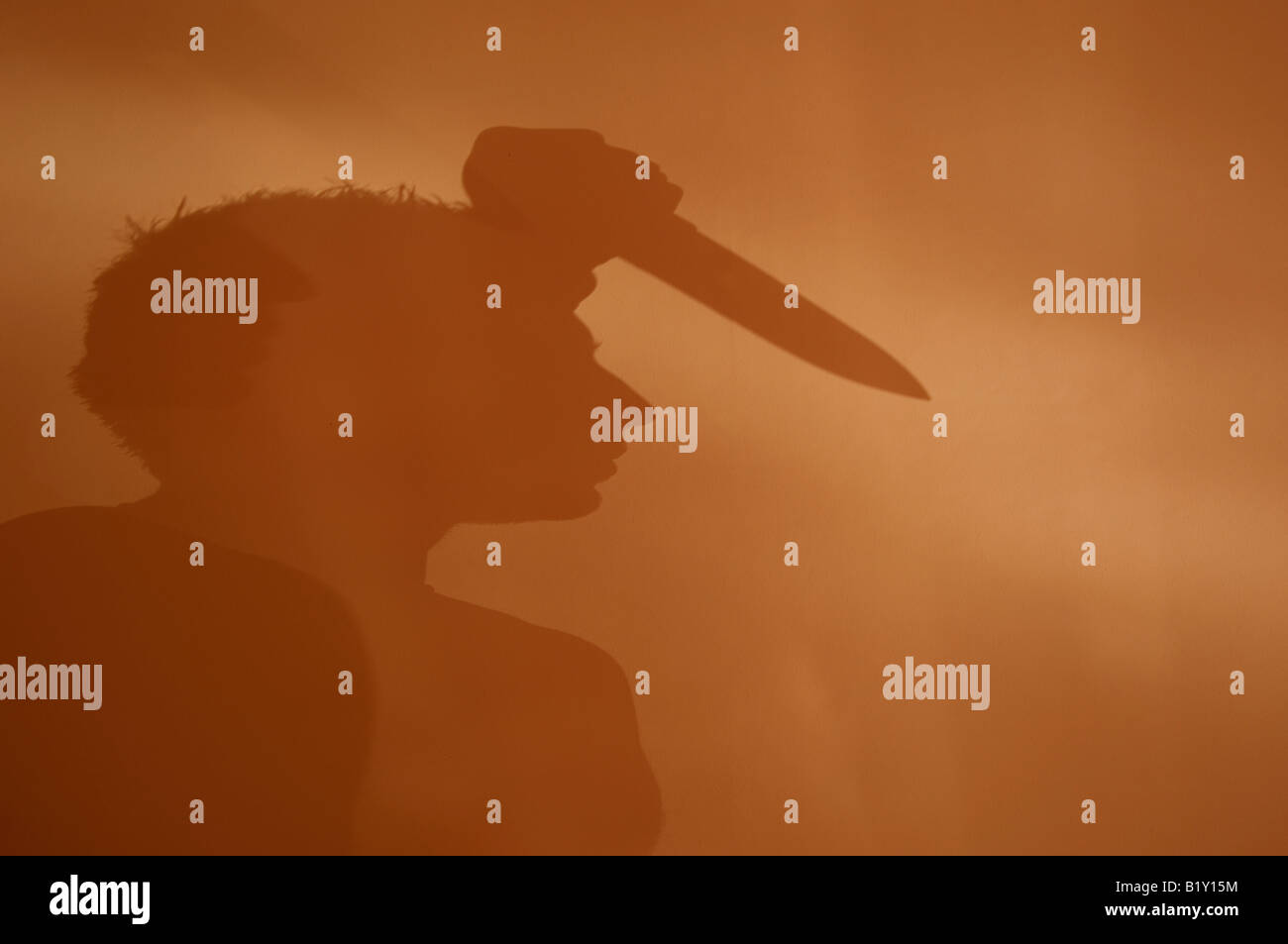 Shadow of a man stabbing with a knife Stock Photo