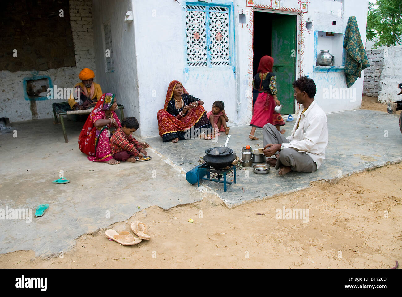Family cooking food in courtyard of a house in Rajasthan, India. Stock Photo