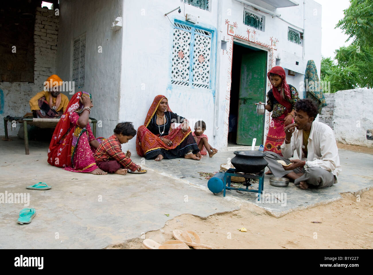 Family cooking food in courtyard of a house in Rajasthan, India. Stock Photo