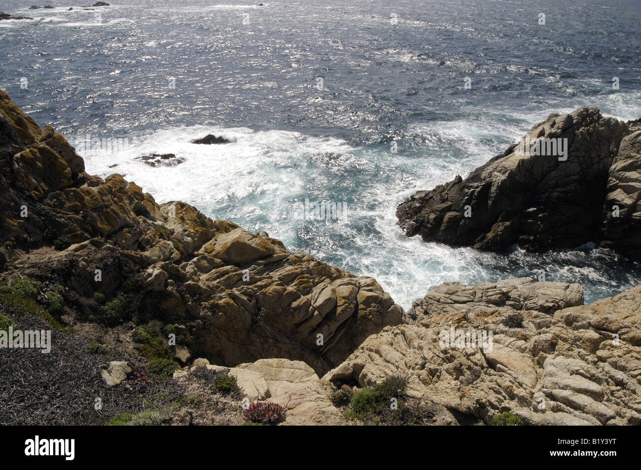 Waves splashing between rocks Stock Photo - Alamy