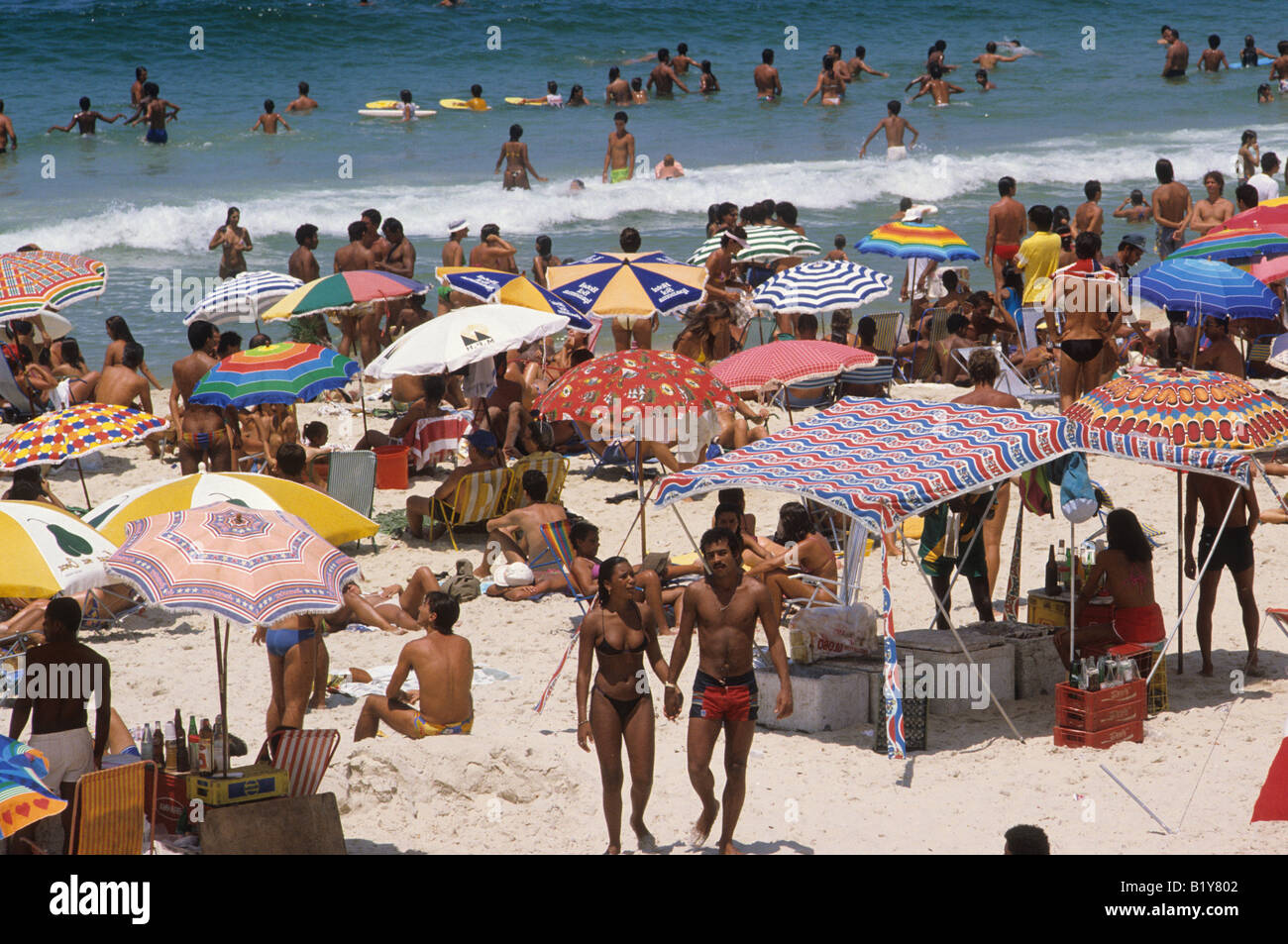 Sunbathers And Swimmers Gather On A Beach In Copacabana Along The Coast Of Rio De Janeiro Brazil