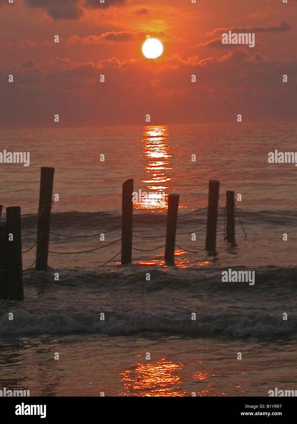 sunrise over the Atlantic Ocean with waves and wooden piers Stock Photo ...