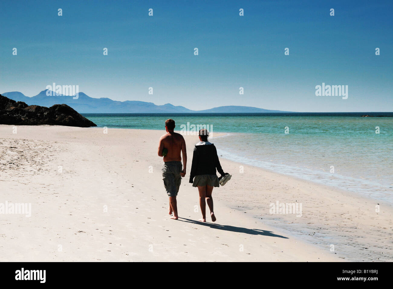 couple strolling alone beach Stock Photo