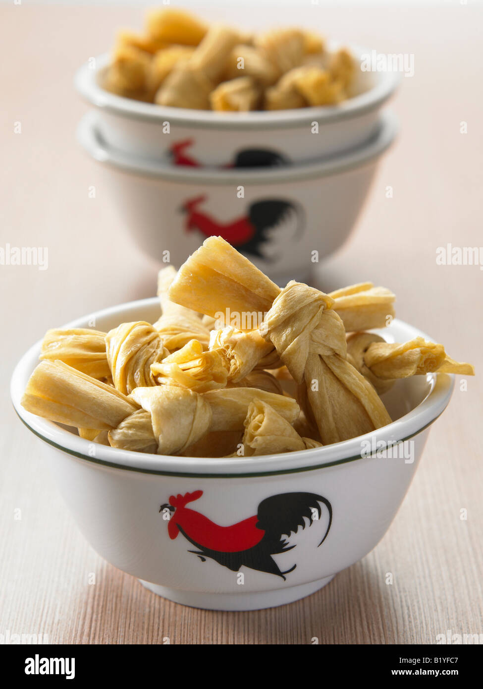 two bowls of dried bean curd skin tie in knots Stock Photo Alamy