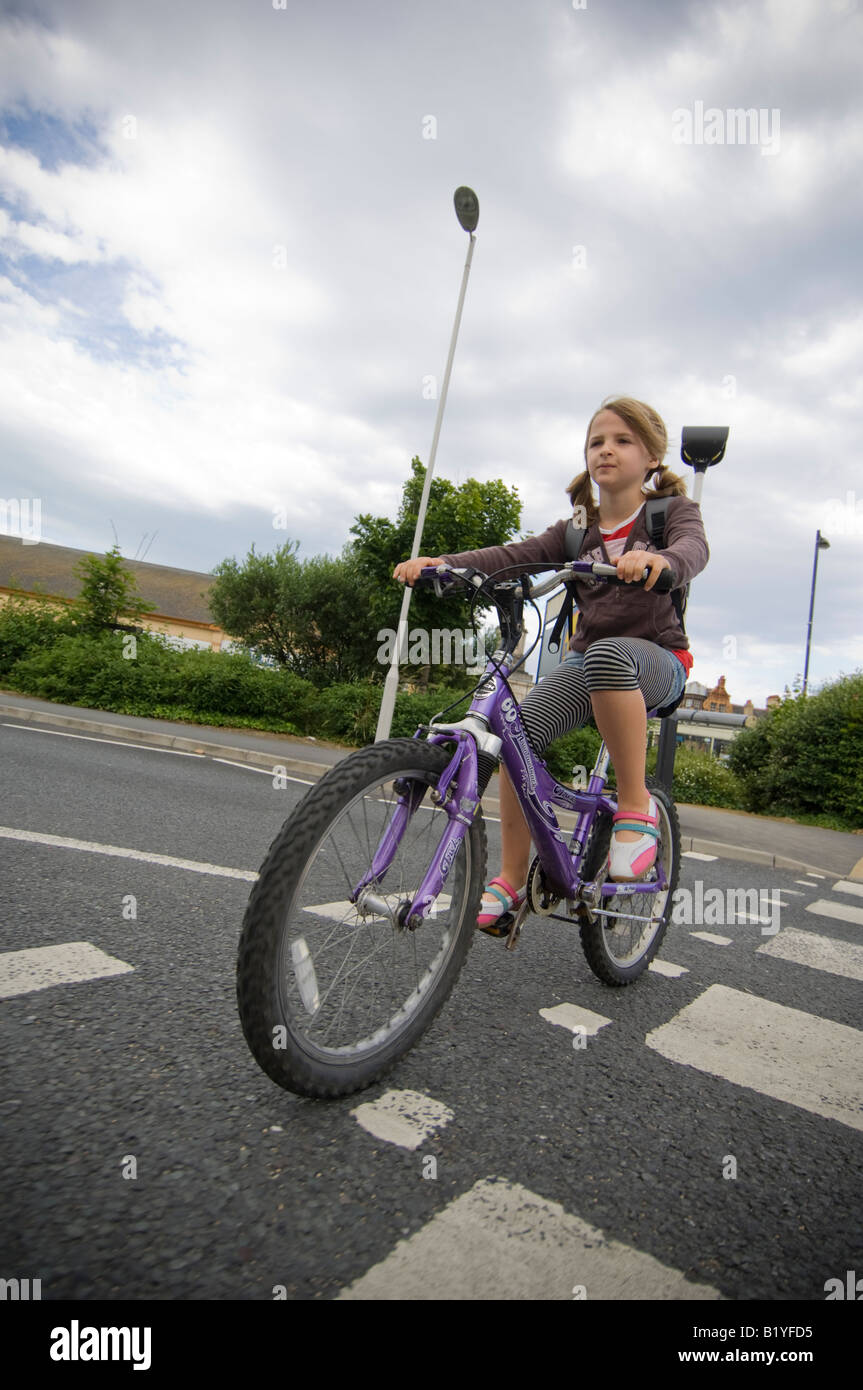 Young 10 year girl cycling alone without helmet to primary school in