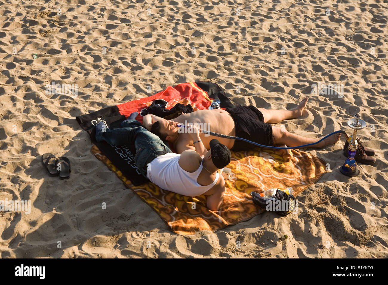 People relax with a shisha on the beach of the Elbe in Oevelgoenne Hamburg Stock Photo