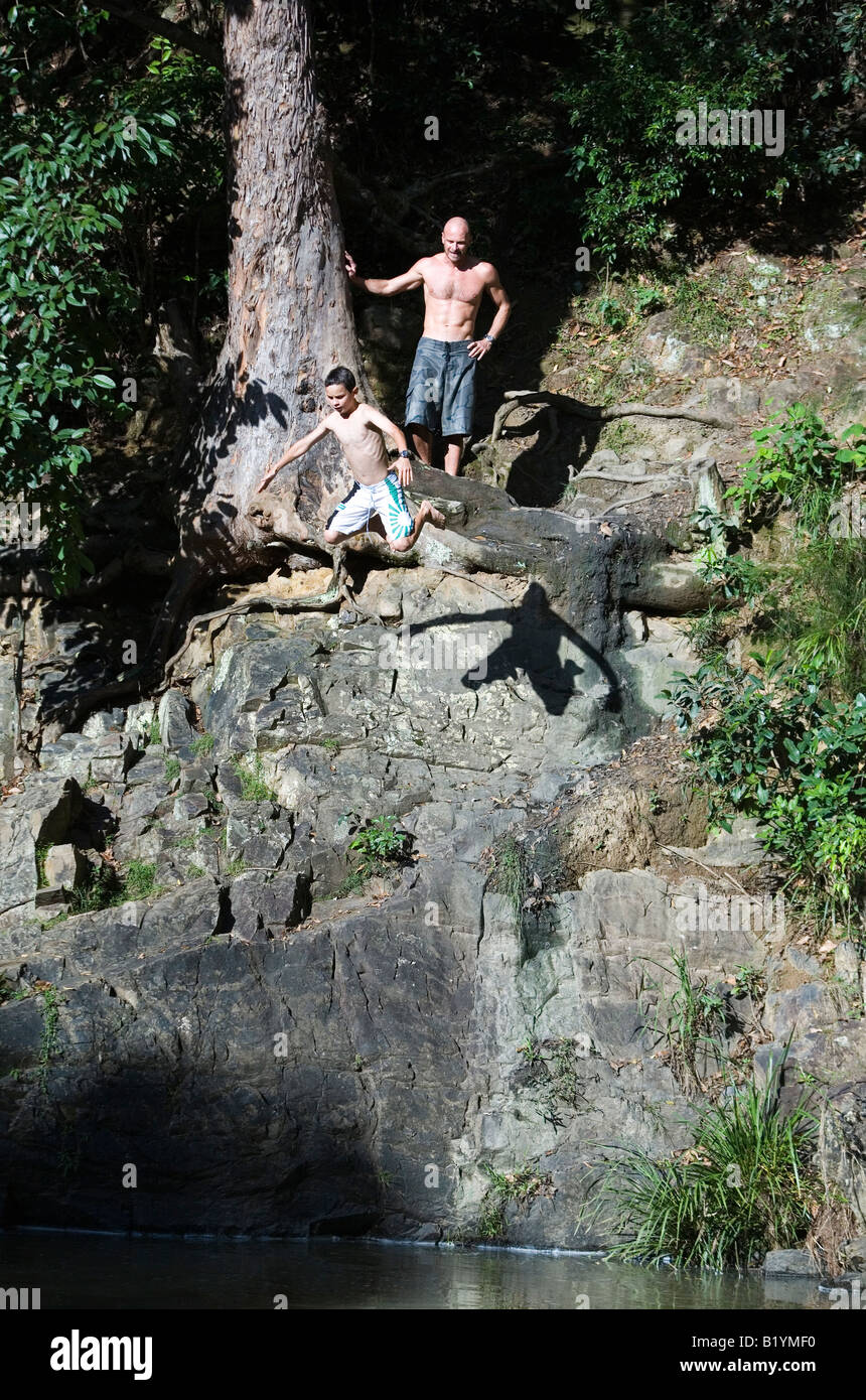 Boy jumping from rock into river, Currumbin Valley Queensland Australia Stock Photo
