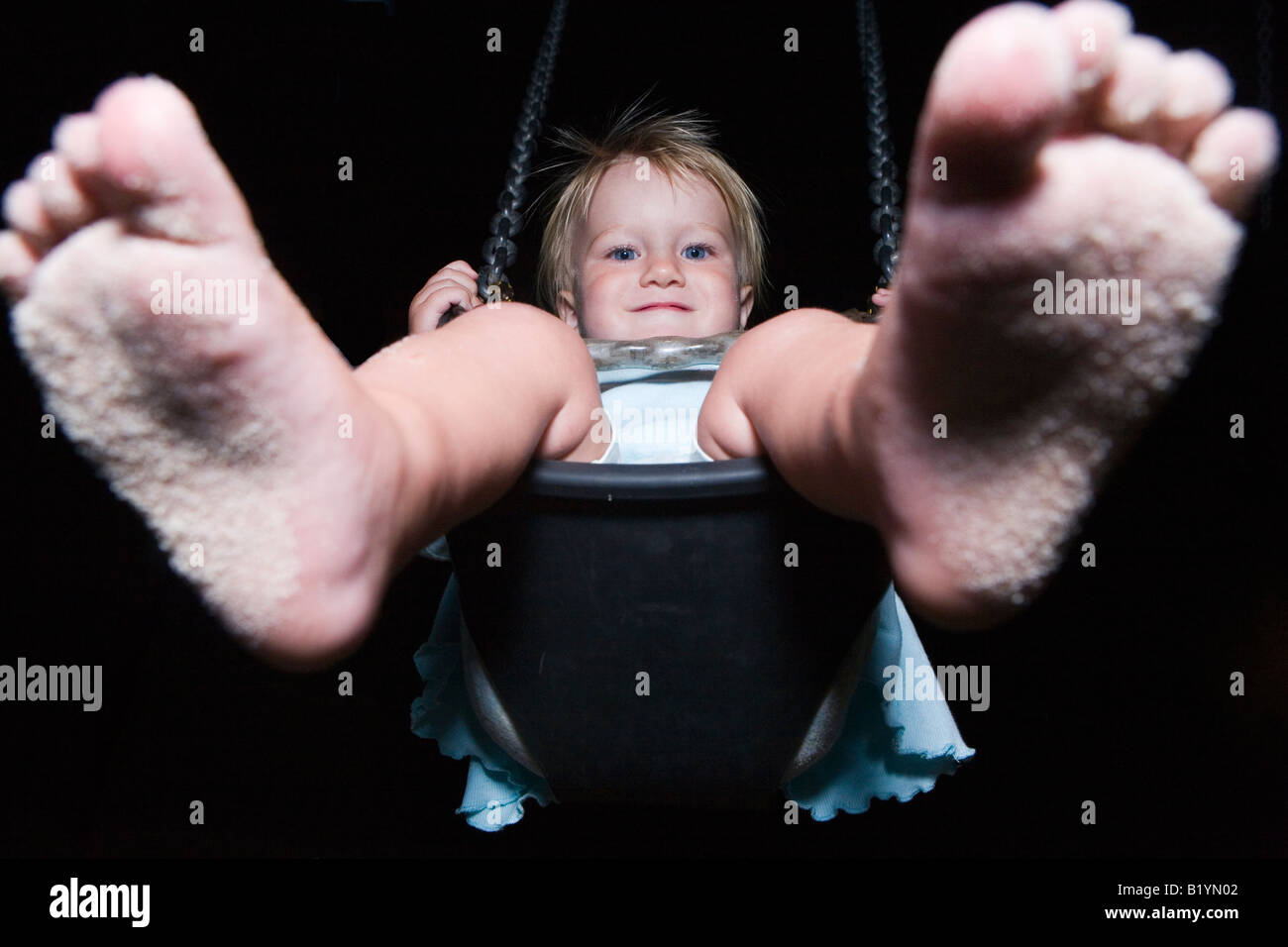 Barefooted girl on a swing feet first Stock Photo