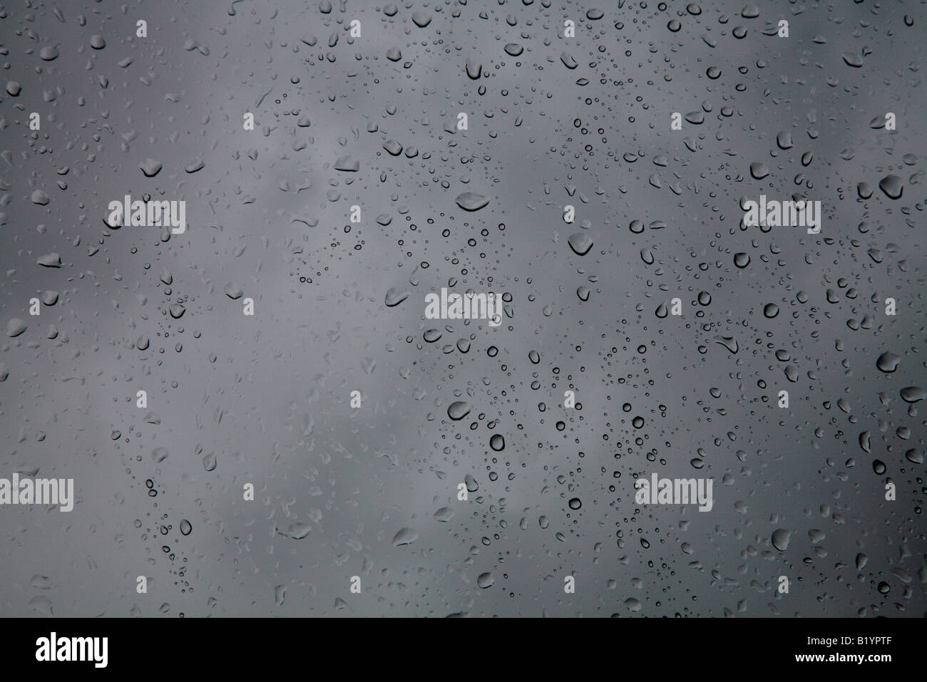 Rain Drops on window pane with dark moody clouds in background Stock ...