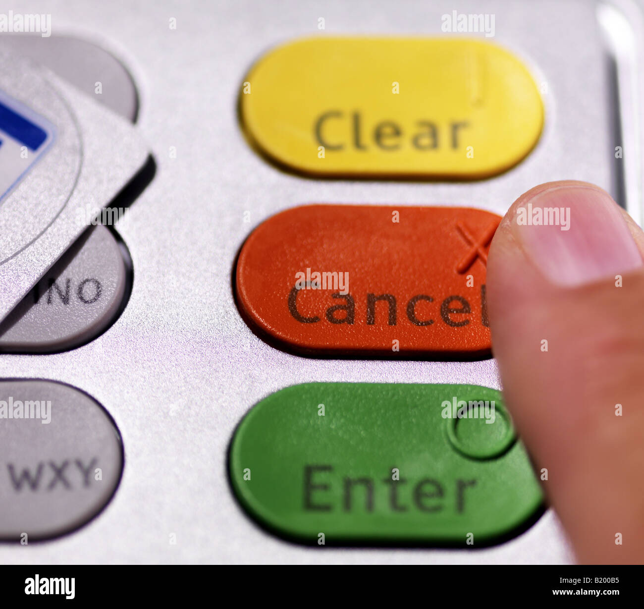Finger about to press 'Cancel' on ATM machine keypad. Stock Photo