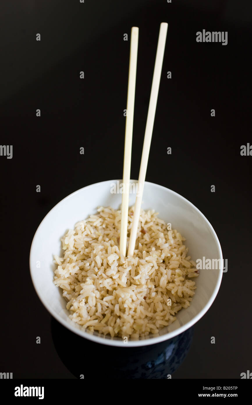 Bowl of brown wholegrain rice and chopsticks Rice has an expensive commodity as its in