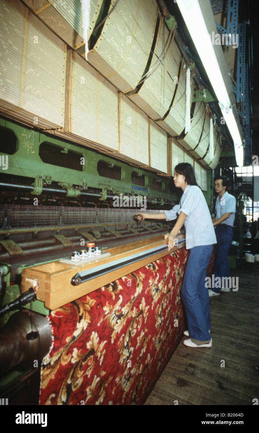 Taiwan.AChinese girl learns from aBritish operator how to manage an Axminster carpet machine.Theyare popular in the Far East Stock Photo