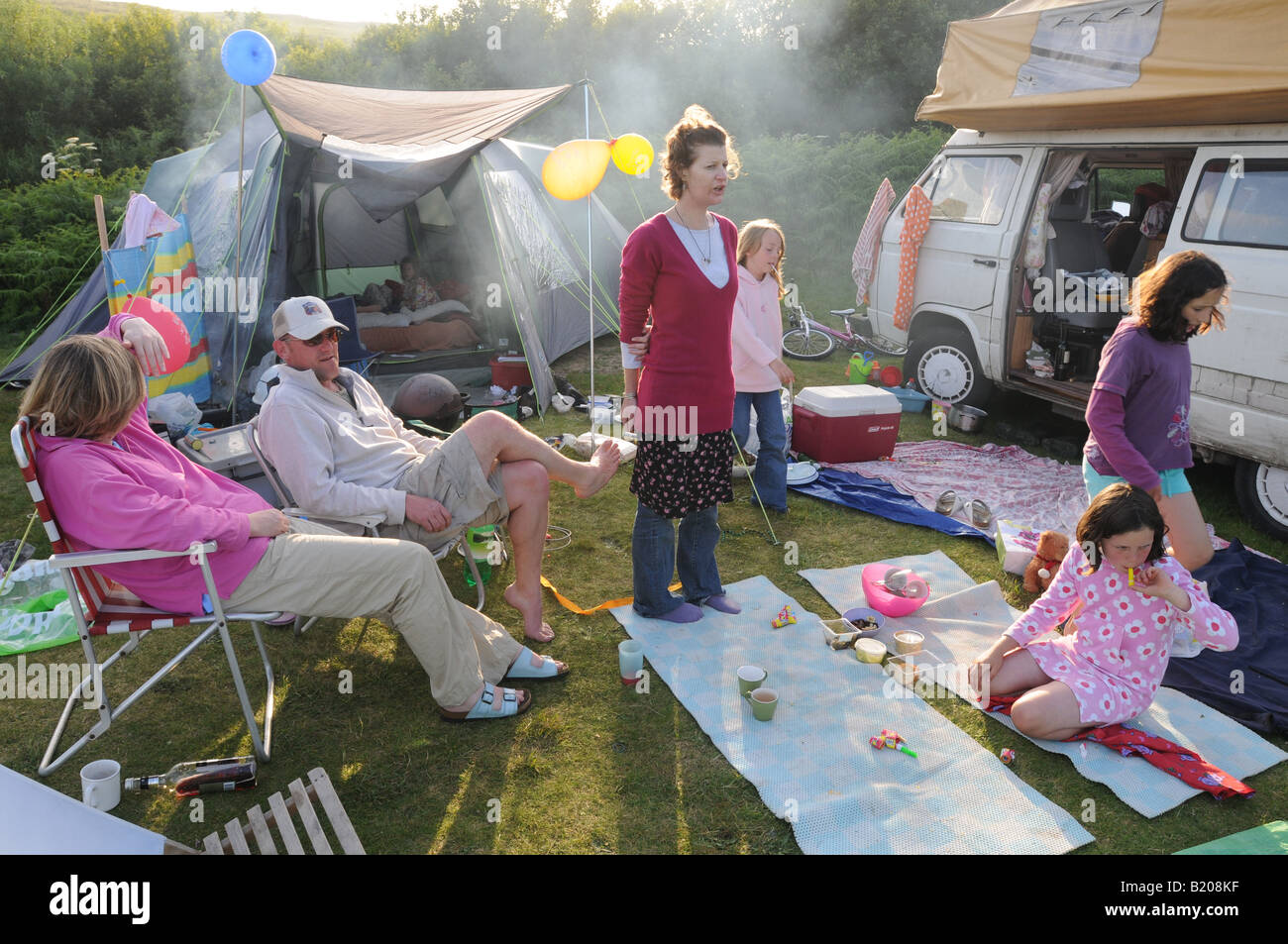 People relaxing on a messy campsite Stock Photo