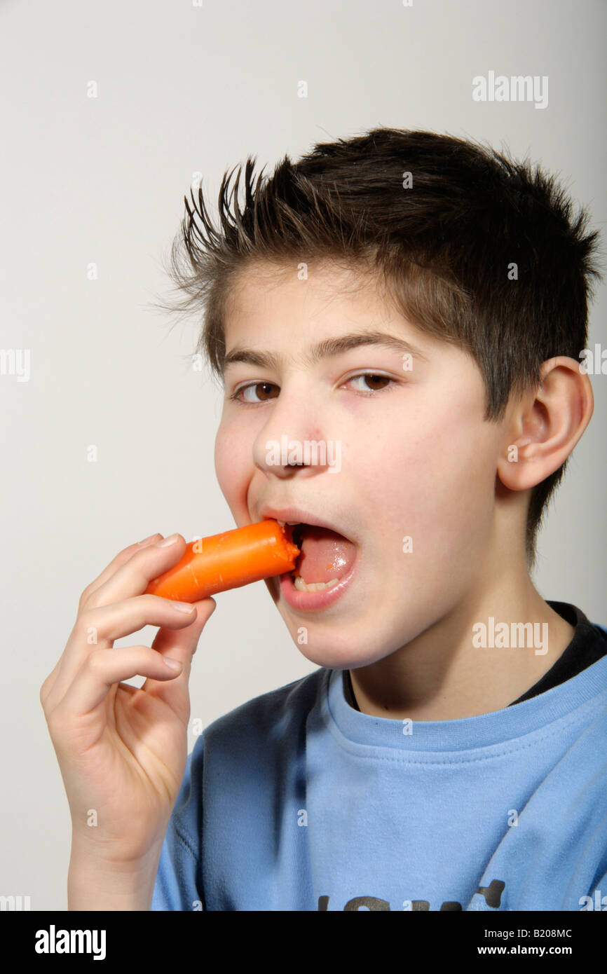 portrait of a young boy eating a carrot Stock Photo