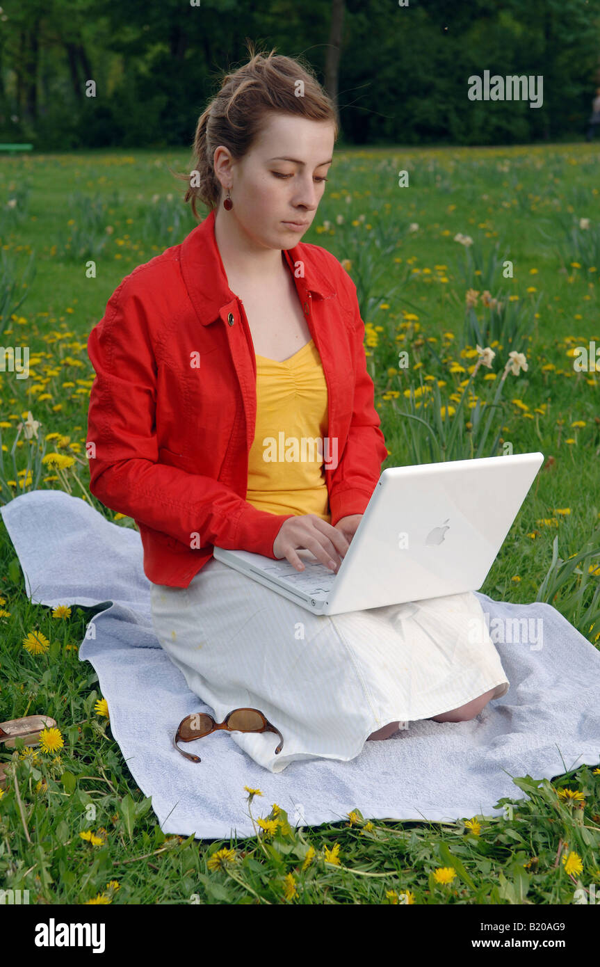 Young woman working on her laptop in a park Stock Photo - Alamy