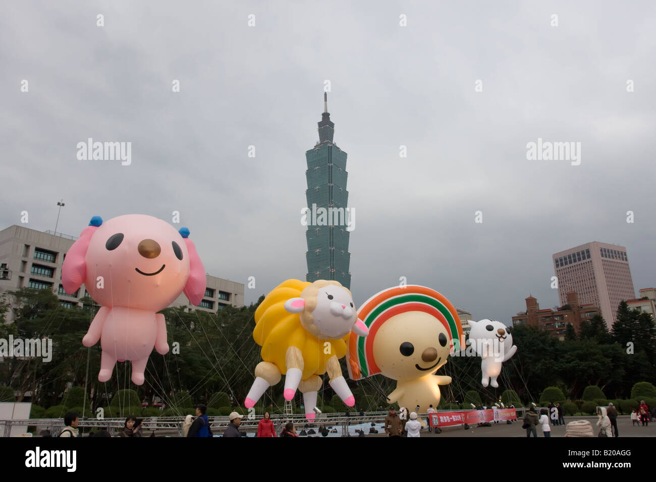 Blowup puppets float just above the ground with Taipei 101 in the