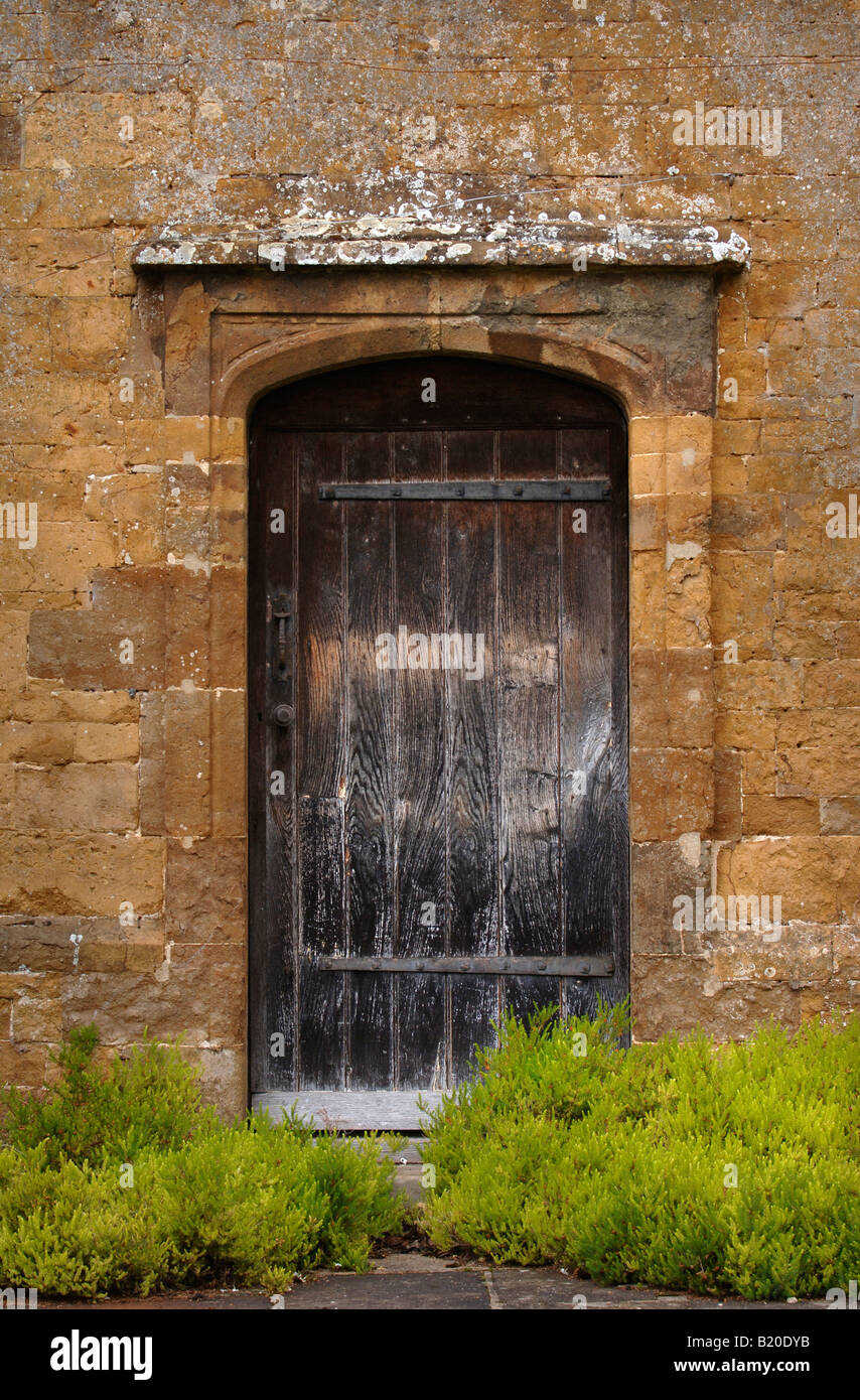 A WOODEN DOOR IN A COTSWOLD WALLED GARDEN UK Stock Photo
