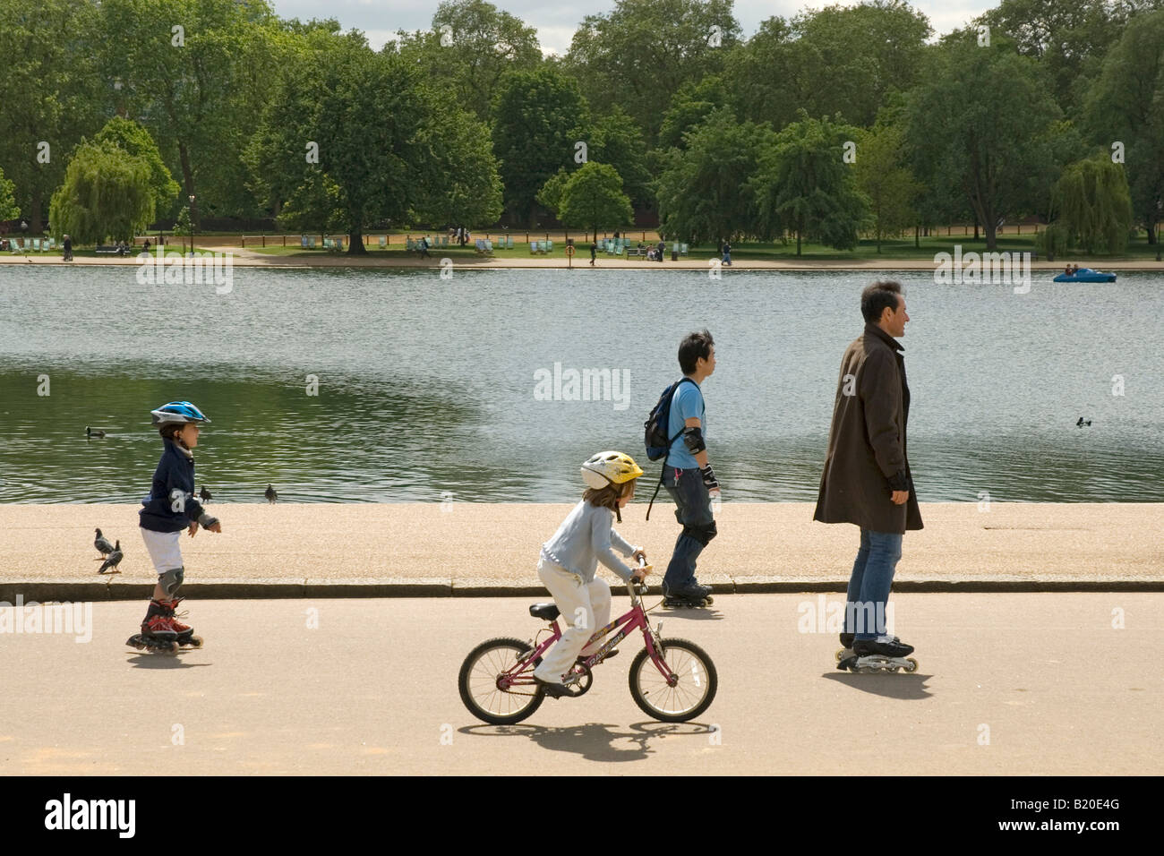 People on inline skates and girl on a bike, Hyde Park, London, UK Stock