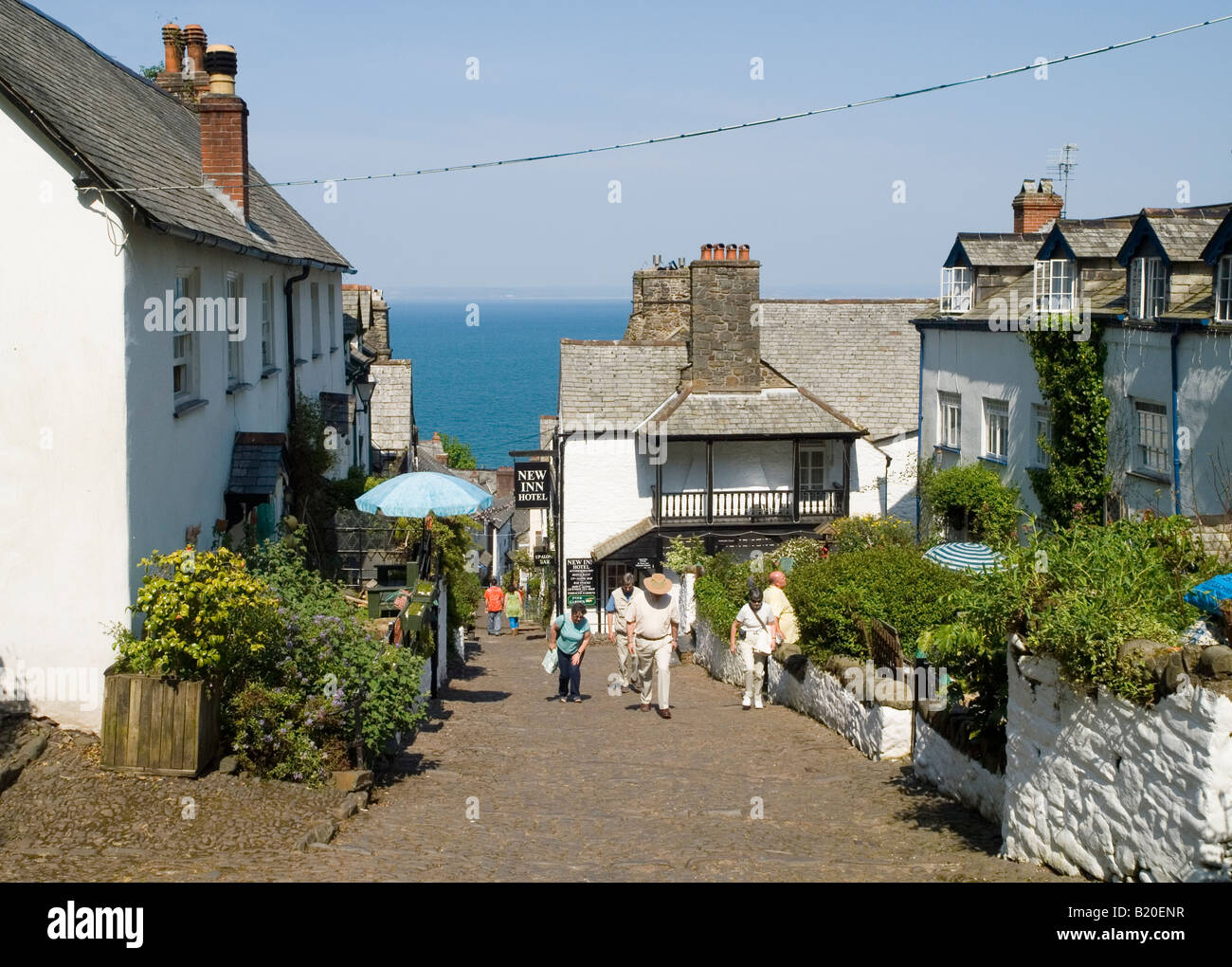 People walking up the steep cobbled street in the historic fishing village of Clovelly, North Devon England UK Stock Photo