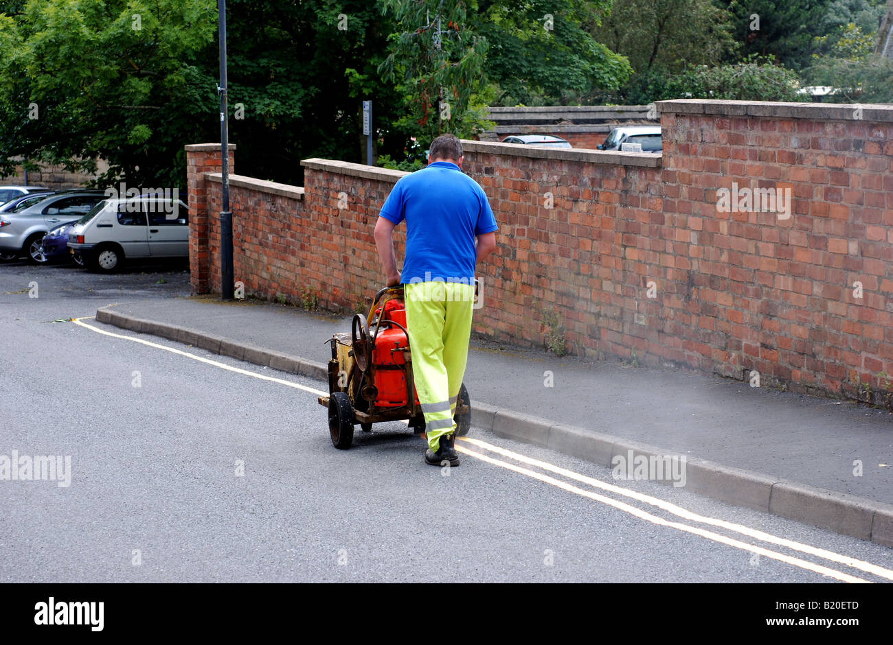 Man painting double yellow lines on a road, UK Stock Photo Alamy