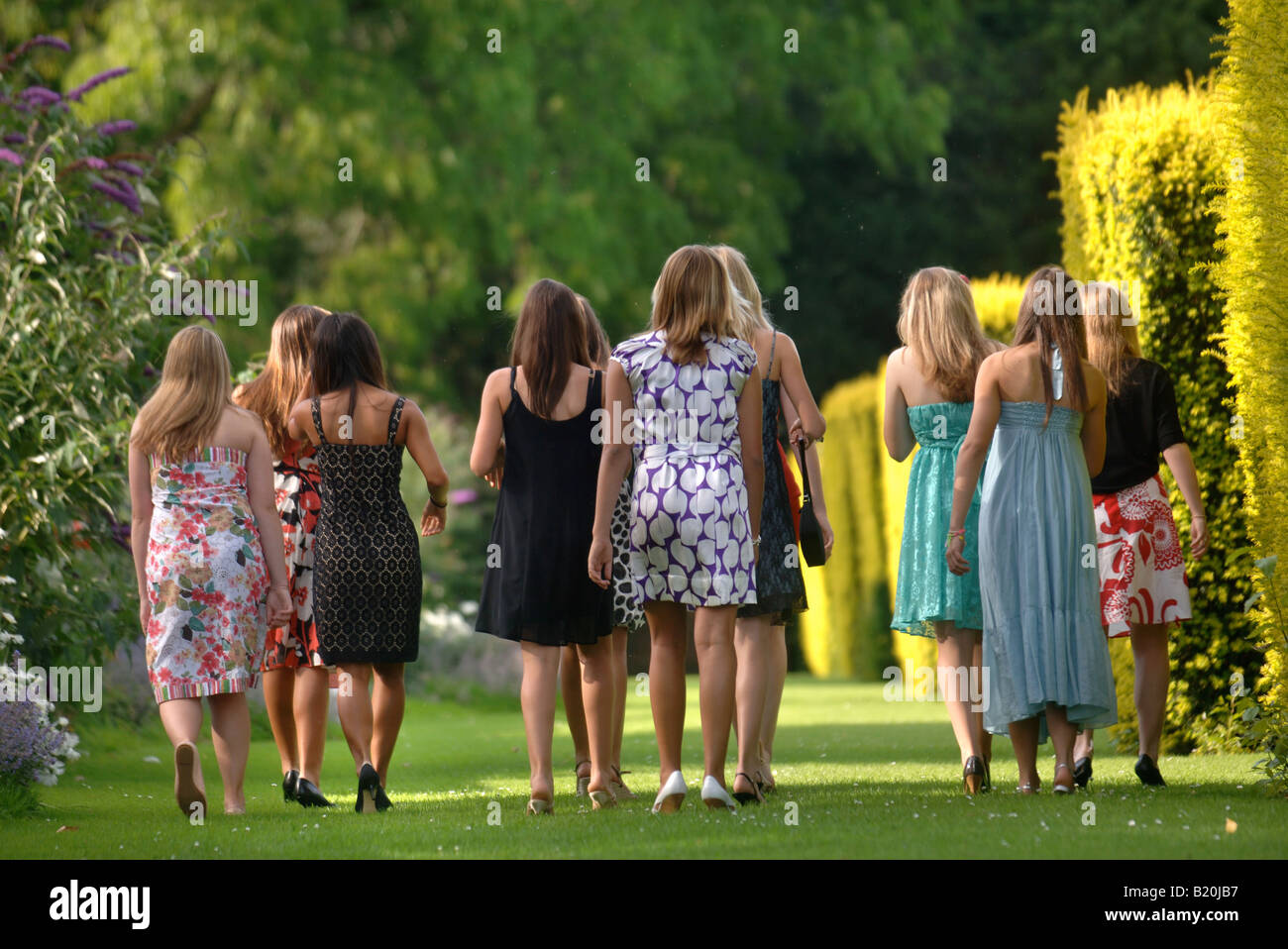 YOUNG WOMEN IN PARTY DRESSES AT A SUMMER GARDEN FUNCTION UK Stock Photo