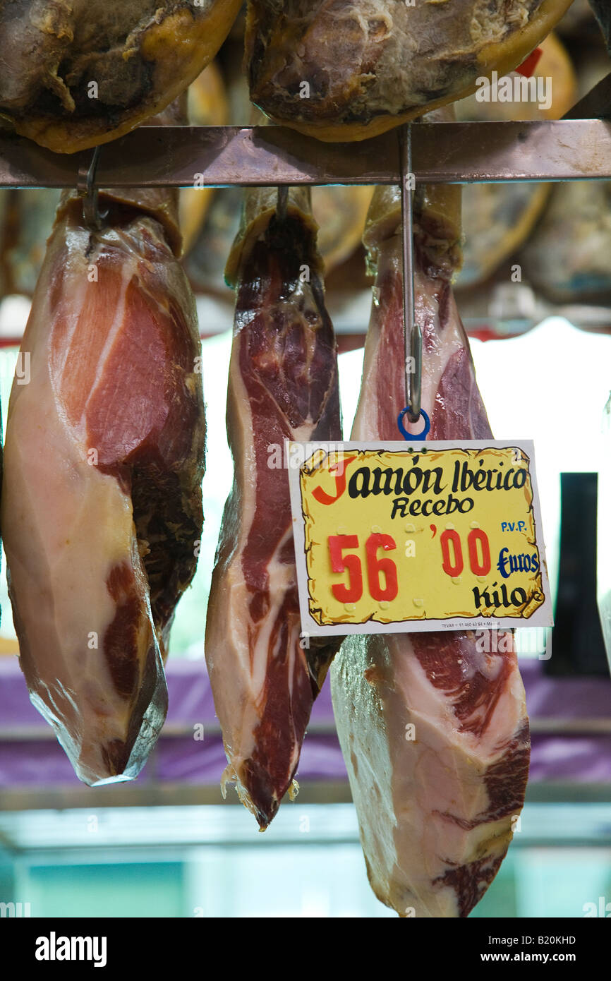 SPAIN Madrid Pigs legs hanging on display in museo de jamon retail store Iberico on sign in Spanish and price in euros Stock Photo
