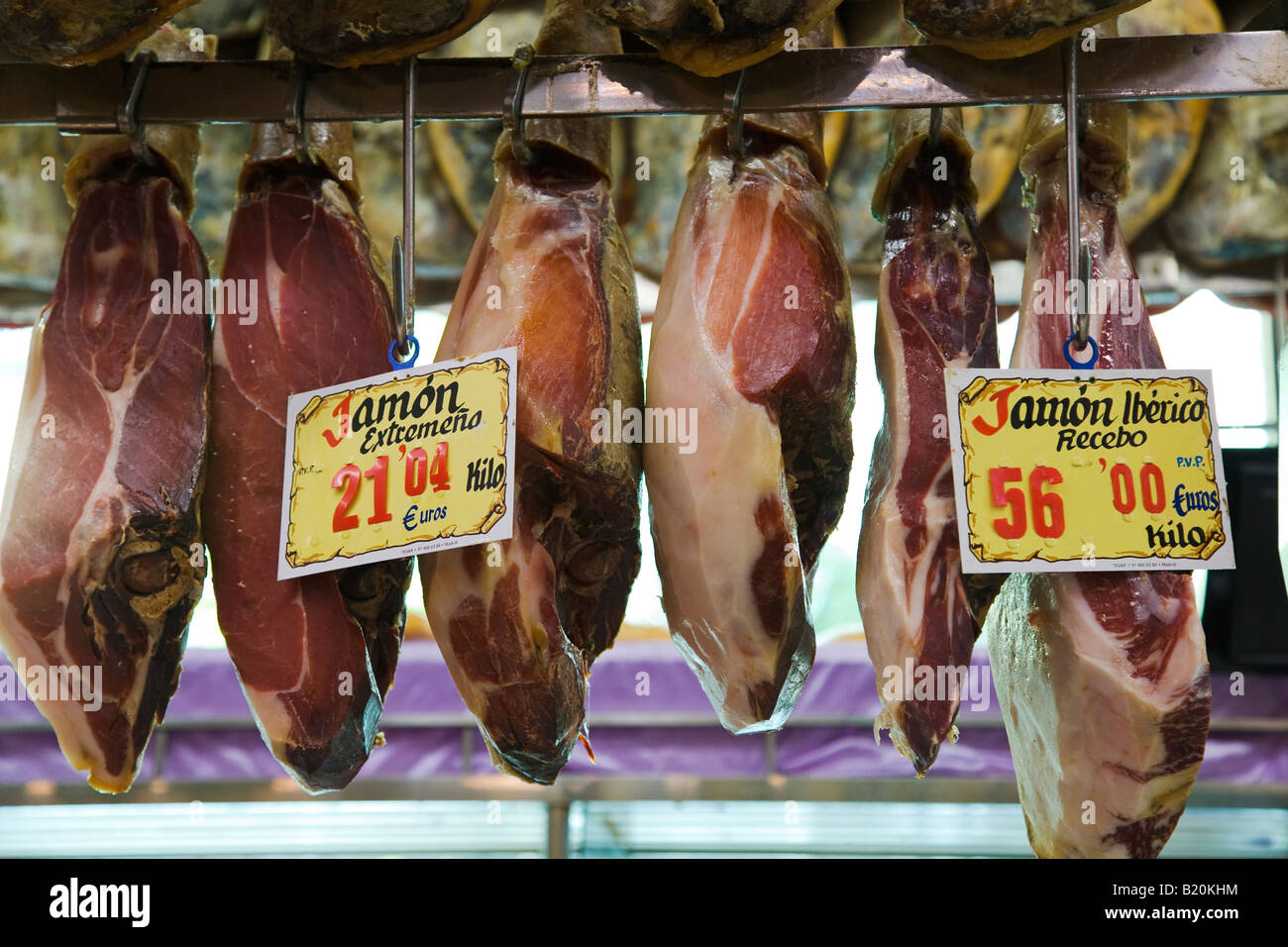 SPAIN Madrid Pigs legs hanging on display in museo de jamon retail store Iberico and Extremeno sign in Spanish and price euros Stock Photo