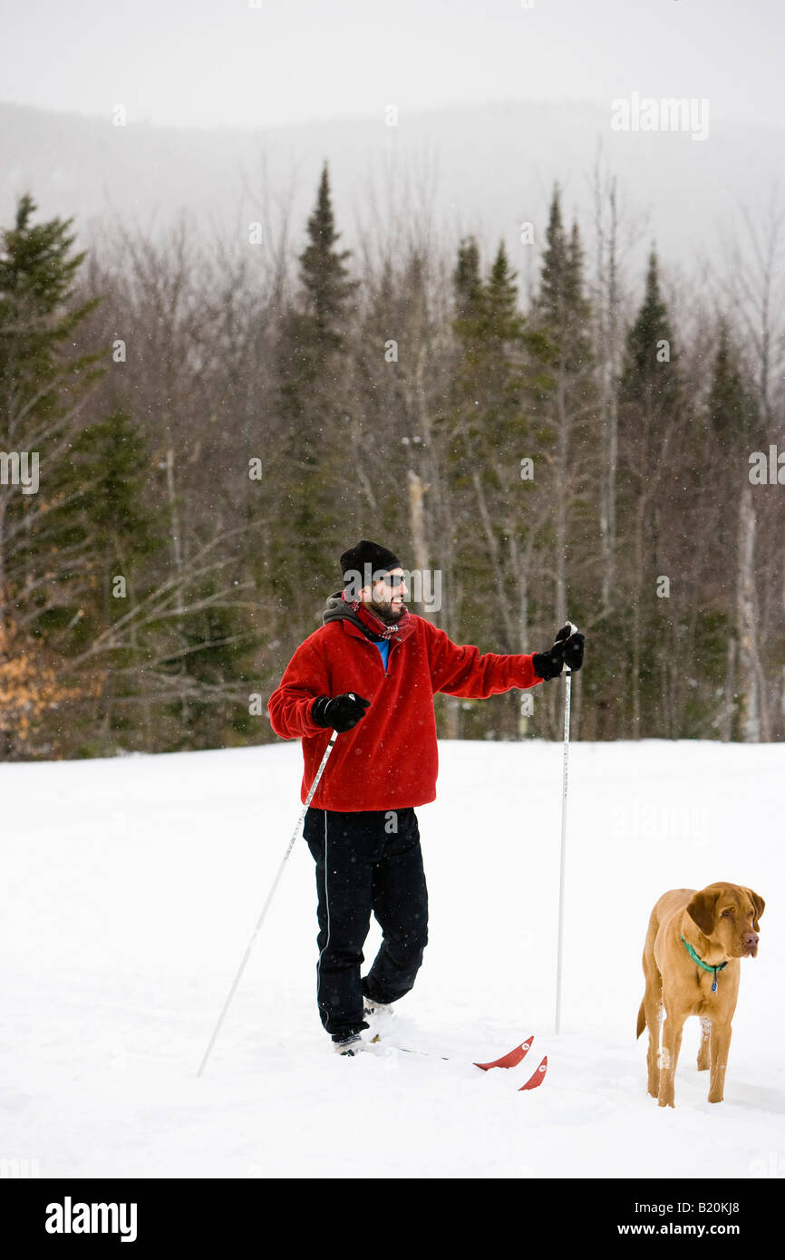 A man cross country skiing with his dog on the Catamount Trail in Stowe