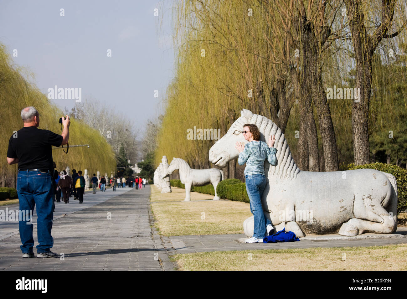 Tourist poses with statue of a resting horse Spirit Way Ming Tombs Beijing Peking China Stock Photo