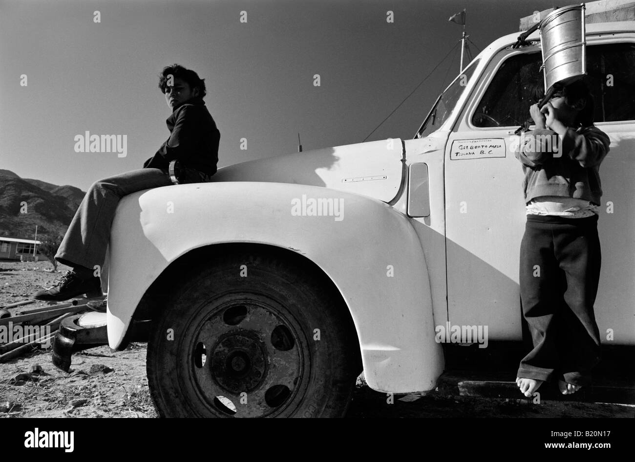 Boys playing on old truck Bahia de los Angeles Mexico Stock Photo