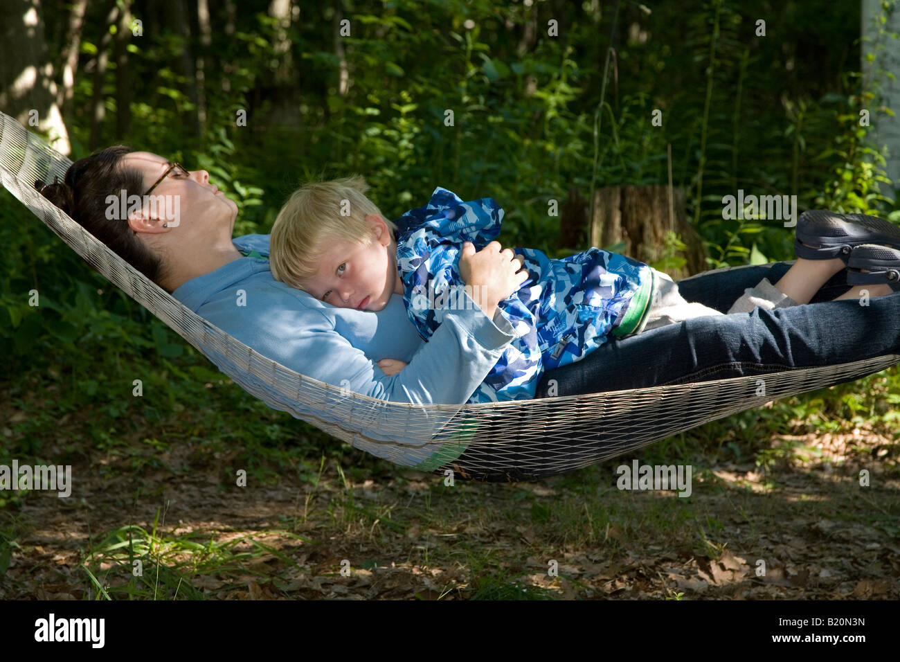 Prairieville Michigan A two year old boy relaxes with his mother on a hammock Stock Photo