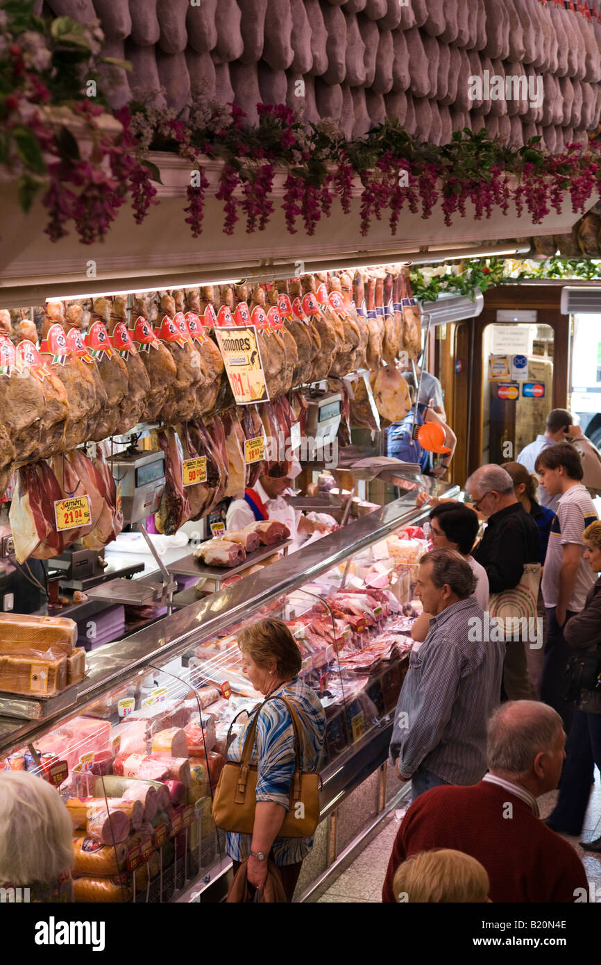 SPAIN Madrid Customers lined up at counter of museo de jamon retail store pigs legs hanging on display Stock Photo