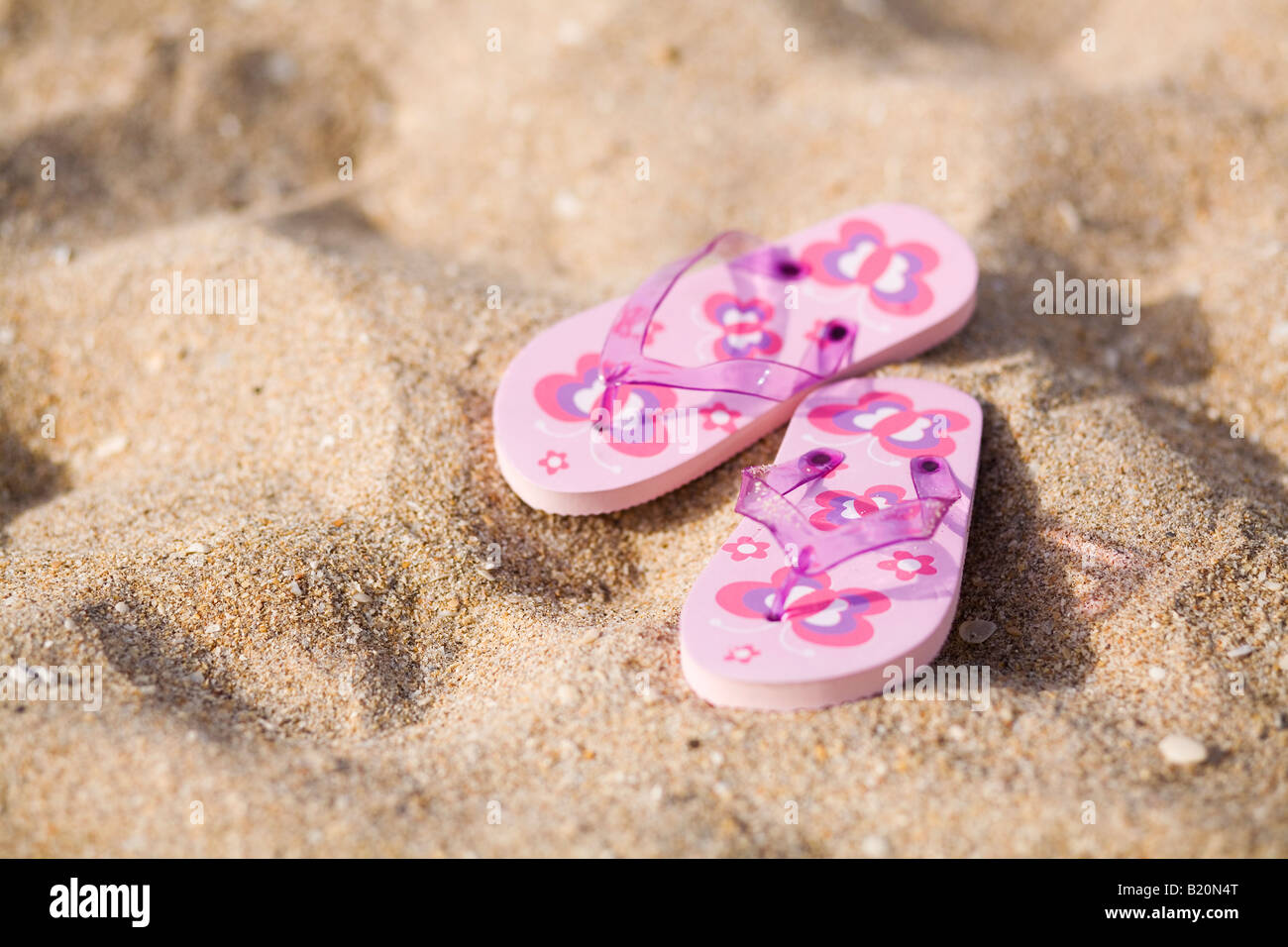 Pair of pink flip flops  on the beach. Stock Photo