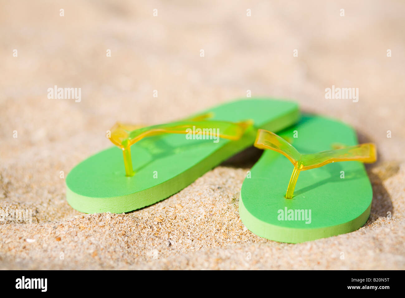 Pair of green flip flops on the beach Stock Photo - Alamy