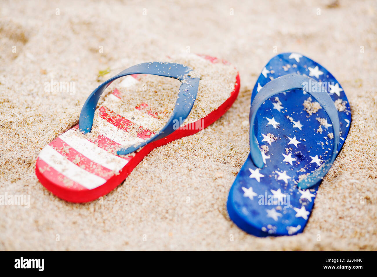 Star and stripes flip flops in the sand Stock Photo