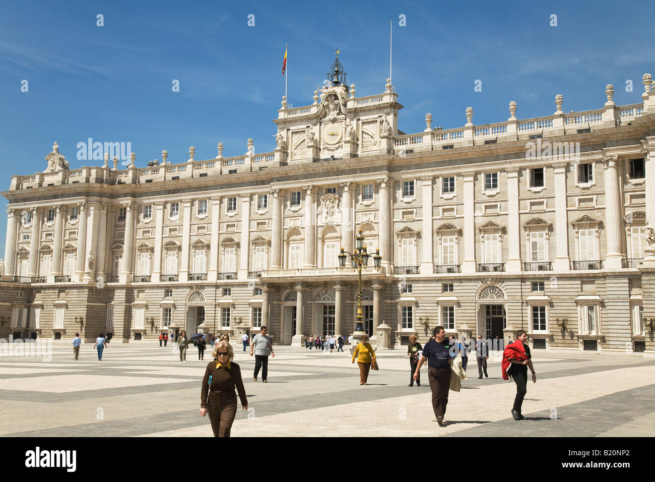 SPAIN Madrid People walking across square outside Royal Palace built by King Philip V in 18th century with more than 2000 rooms Stock Photo