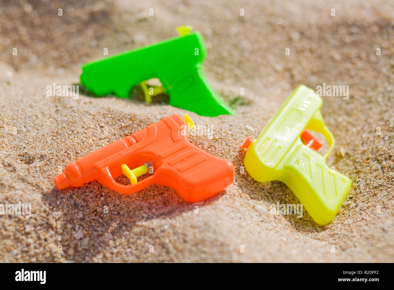 Colorful water guns in the sand on the beach Stock Photo Alamy