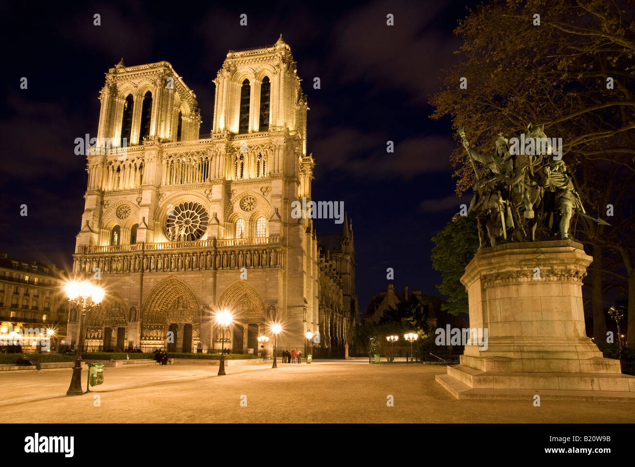 Notre Dame Cathedral West facade entrance Charlemagne floodlit illuminated illuminations in evening night light Paris France Stock Photo