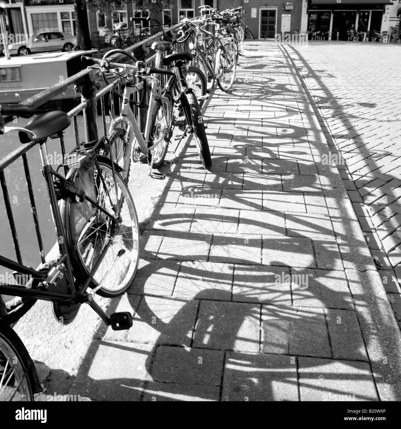 Bicyles Leaning Against Railings with Shadows in Amsterdam North Holland Netherlands Stock Photo