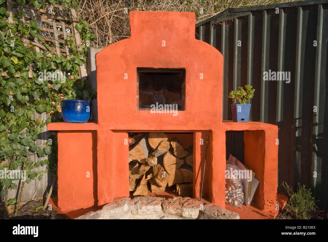 A new custom built wood fired pizza oven rendered in red lime wash Stock Photo