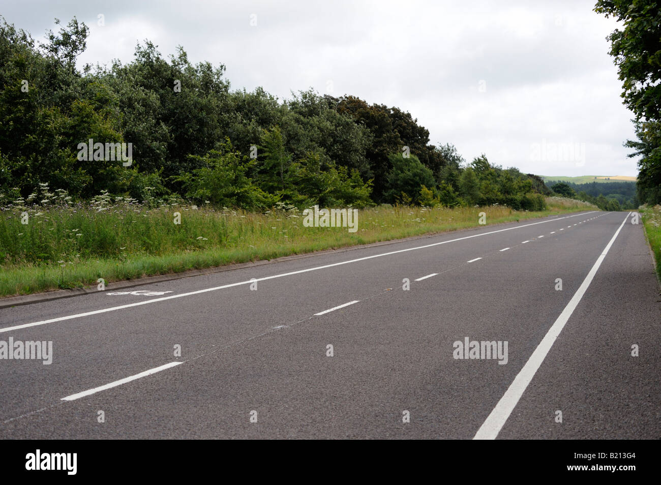 Straight tarmac road, two-way, with cycle lane. Dumfries and Galloway, Scotland, United Kingdom, Europe. Stock Photo
