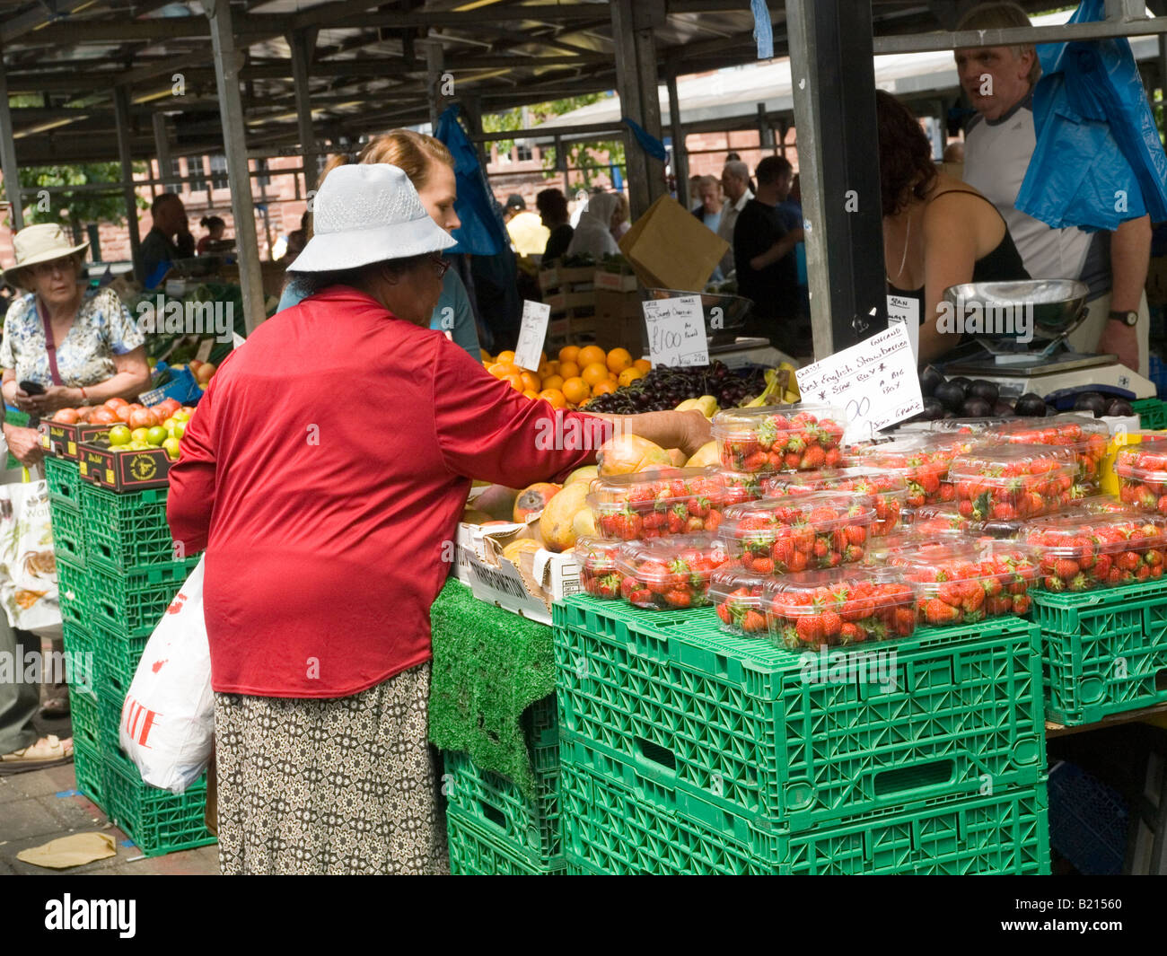 People buying from a fruit and vegetable stall in the Bull Ring Market