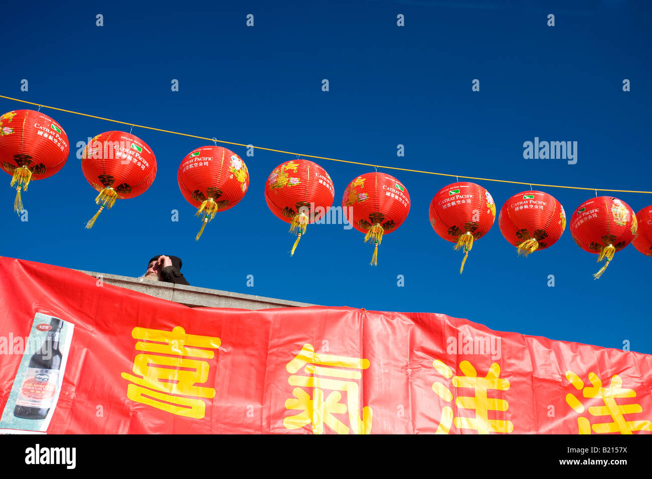 A man peers out over Trafalgar Square during Chinese New Year. Stock Photo