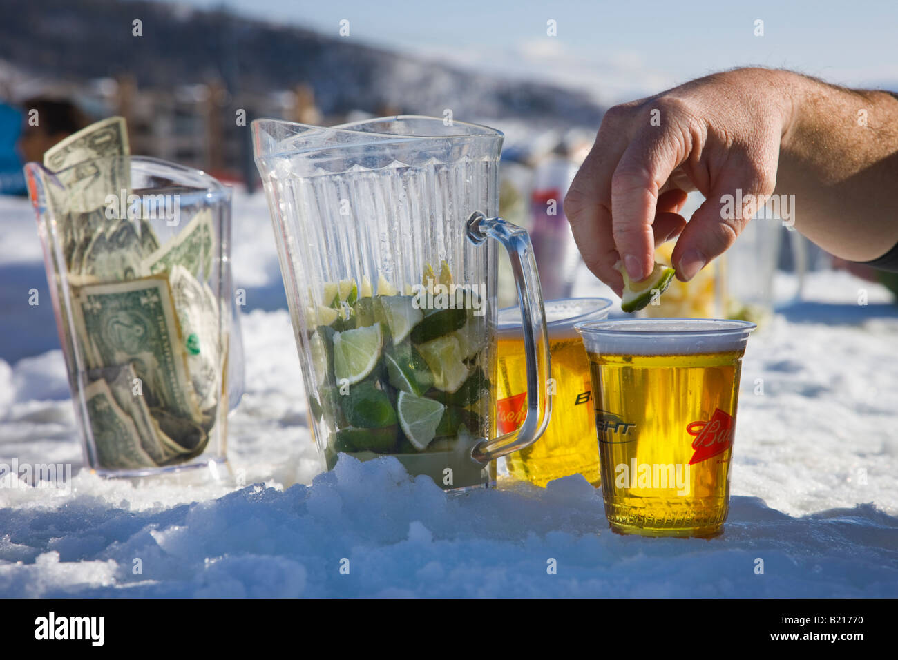 A man drops lime in to his beer at the ice bar in Steamboat Springs ski resort, Colorado, USA. Stock Photo