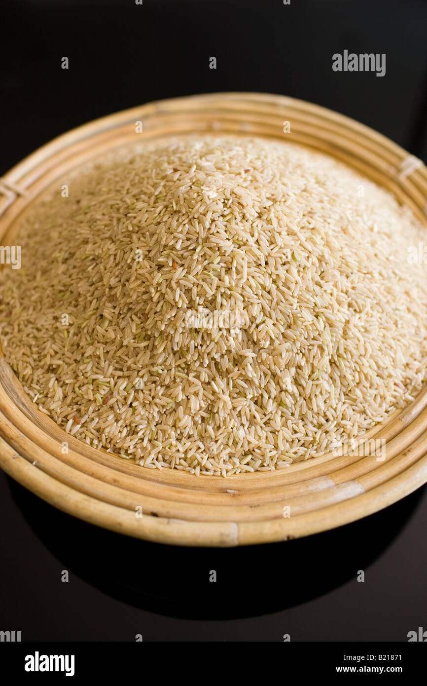 Bamboo basket of brown wholegrain rice Rice has become an expensive commodity as its in short supply Stock Photo