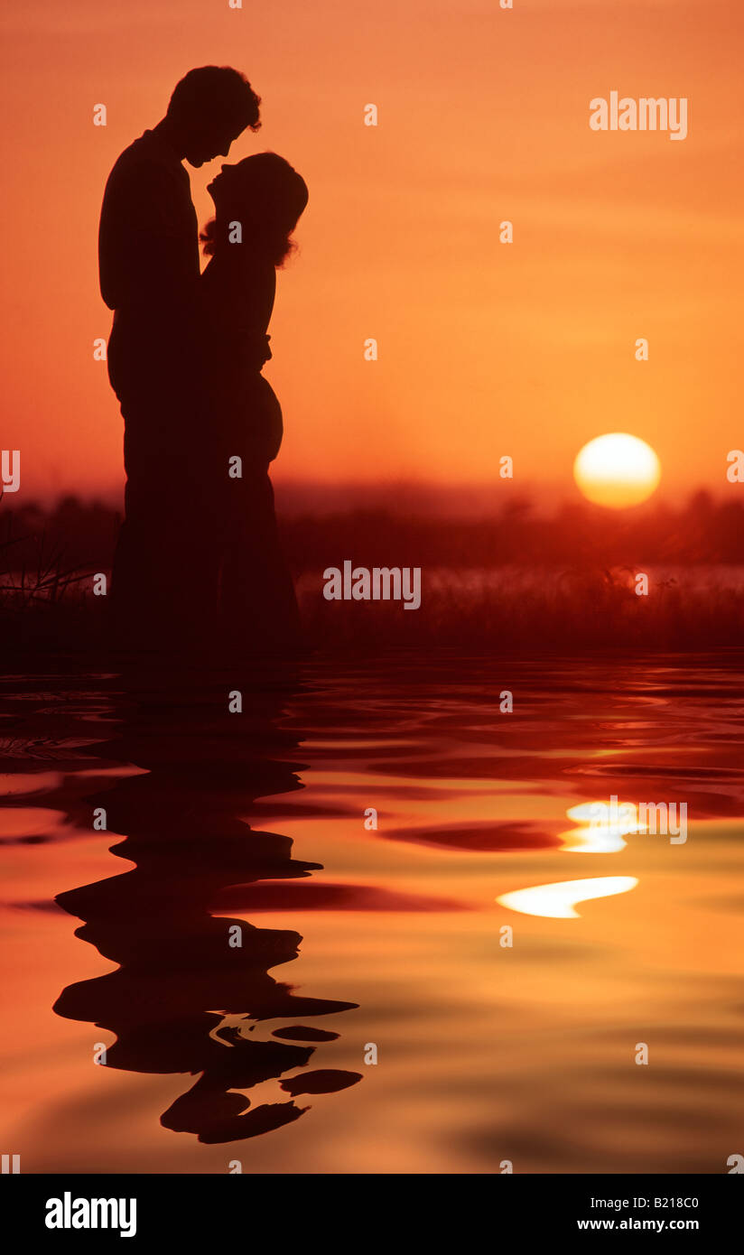 romantic couple embracing on beach at sunset Stock Photo - Alamy