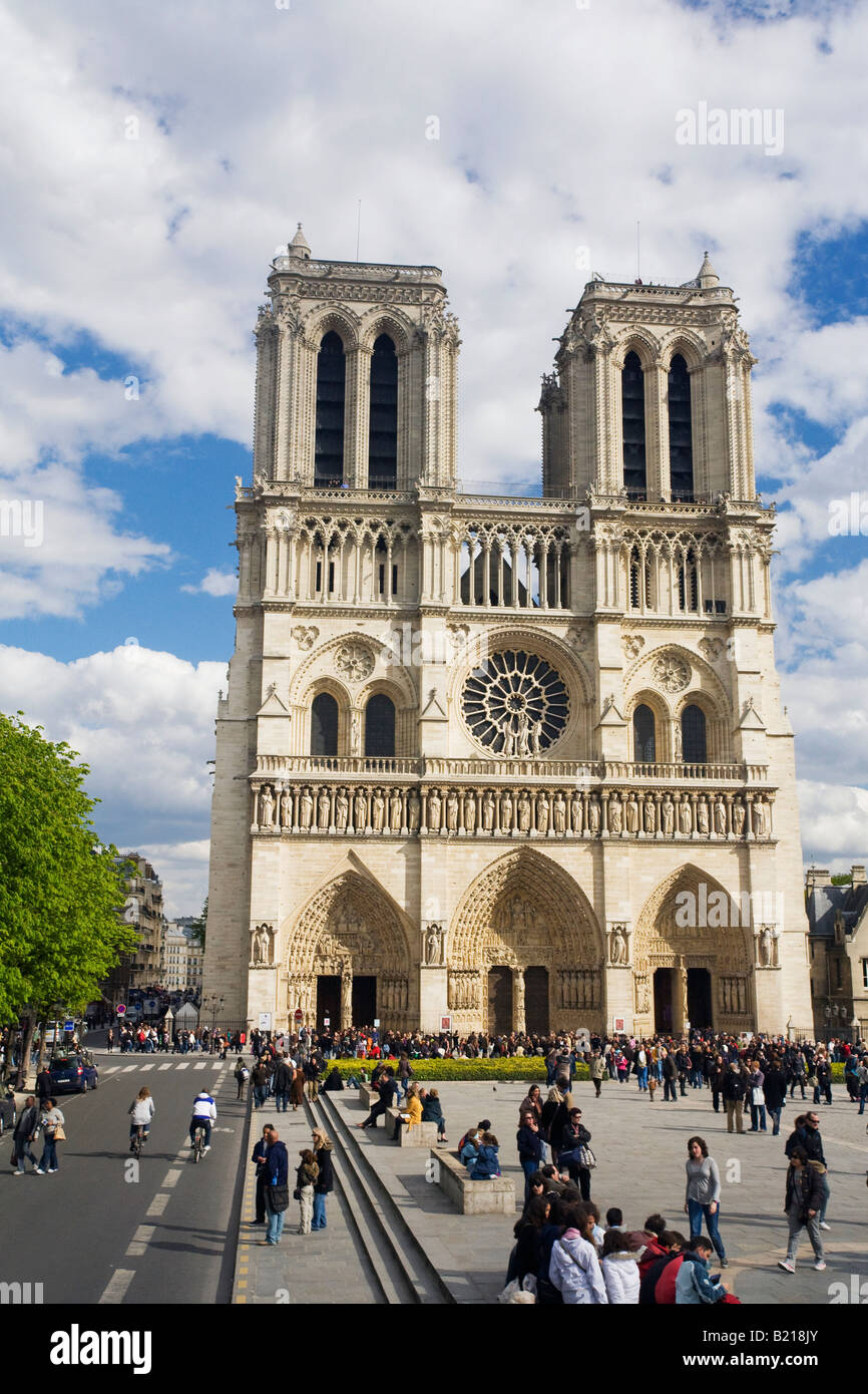 Notre Dame Cathedral exterior west entrance facade with visitors and tourists in spring sunshine Paris France Europe EU Stock Photo