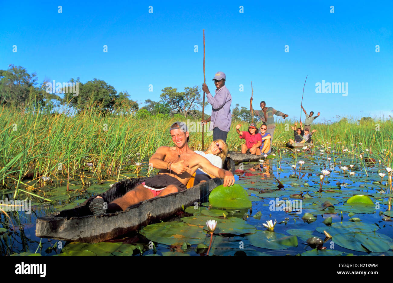 Tourists travel on the Okavango Delta in a Mokoro boat canoe. Stock Photo