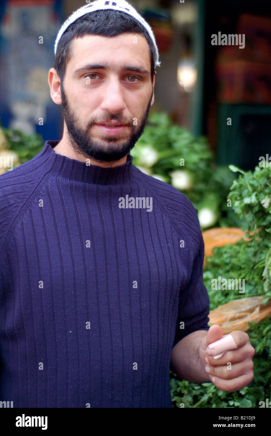 A Jewish market trader takes a break from selling fruit and vegetables in Tel Aviv. Stock Photo